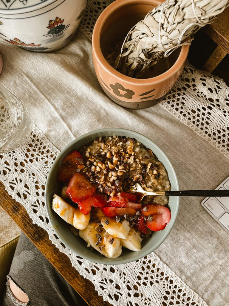 fruity morning oat bowl with sage on feminine desk