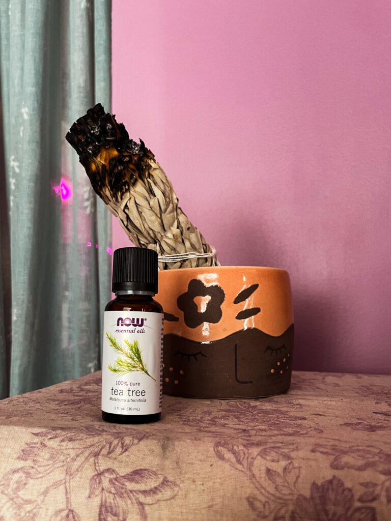 tea tree oil on table against purple wall